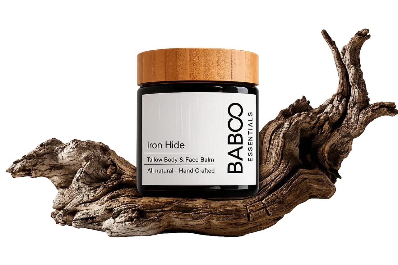 Iron Hide grass-fed tallow balm jar resting on driftwood